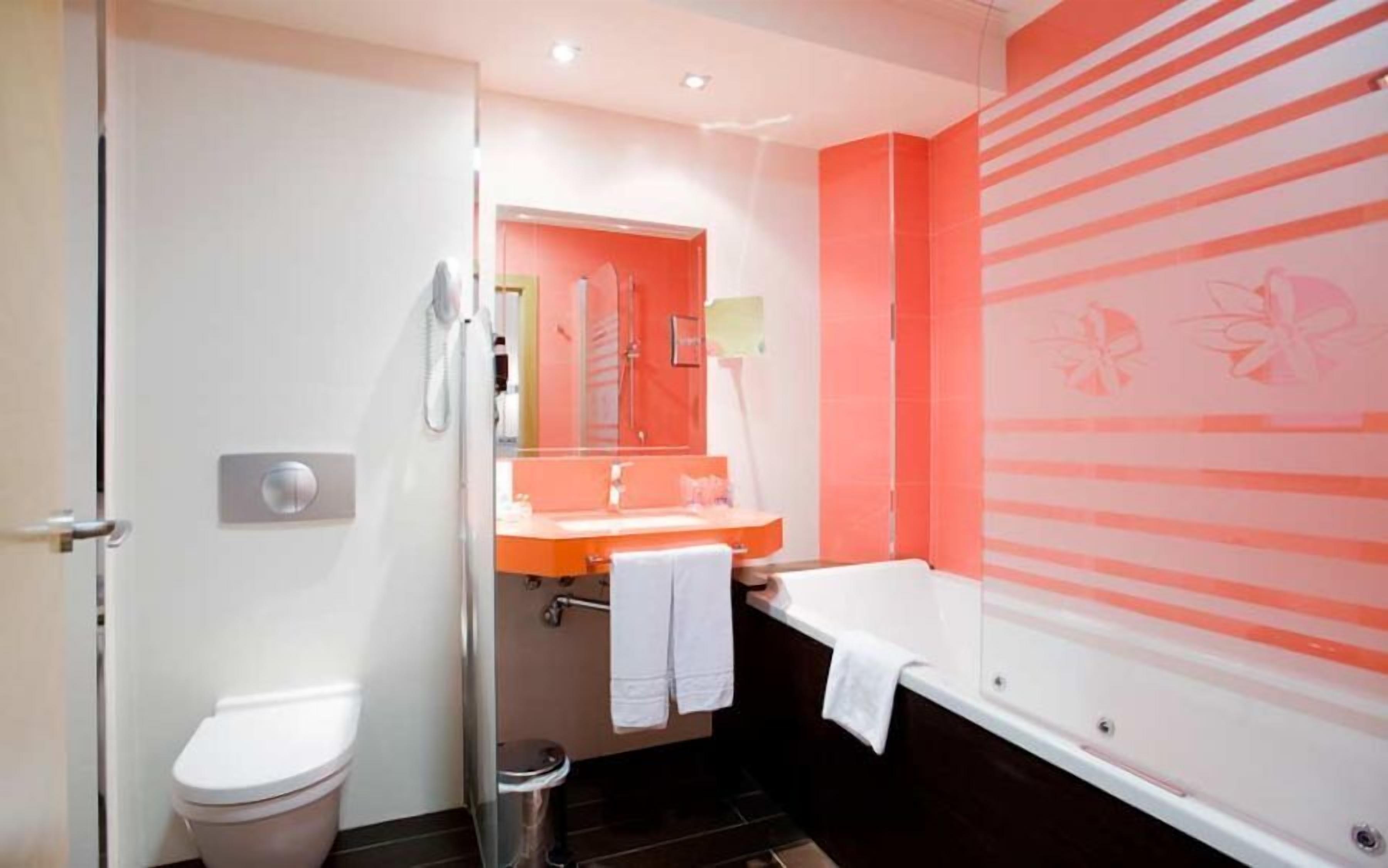 Une salle de bain avec des toilettes, un lavabo et une baignoire.