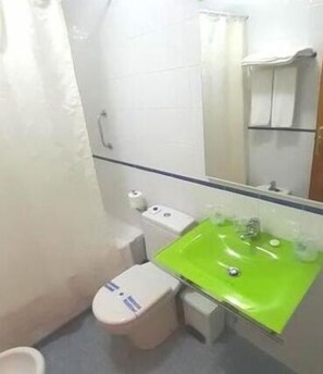 A small bathroom with a green sink, a white toilet, and a mirror above the sink. - Hotel Hórreo by Bossh! Hotels (Santiago de Compostela)