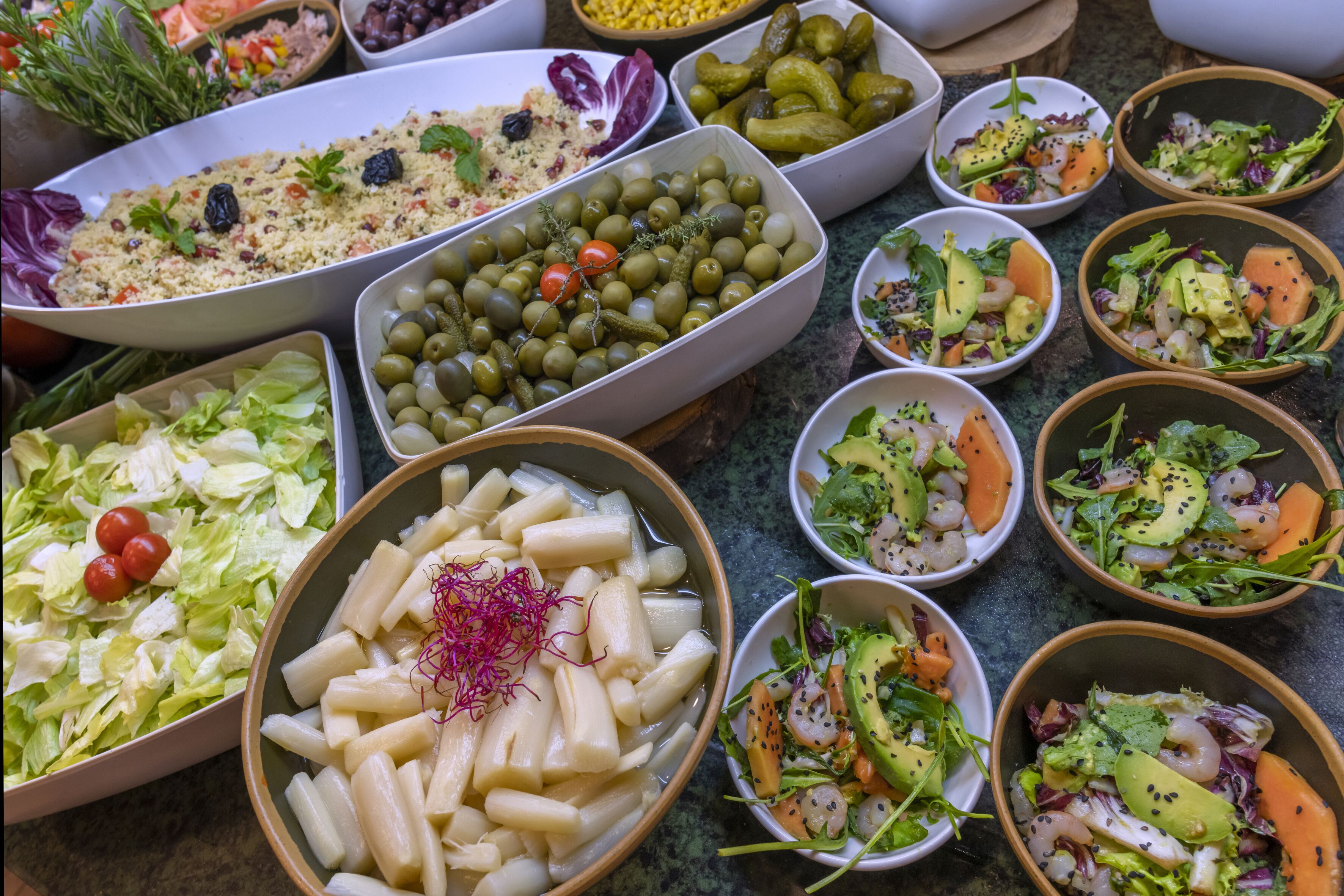 Diverse gerechten, waaronder salades, ingelegde groenten en granen.