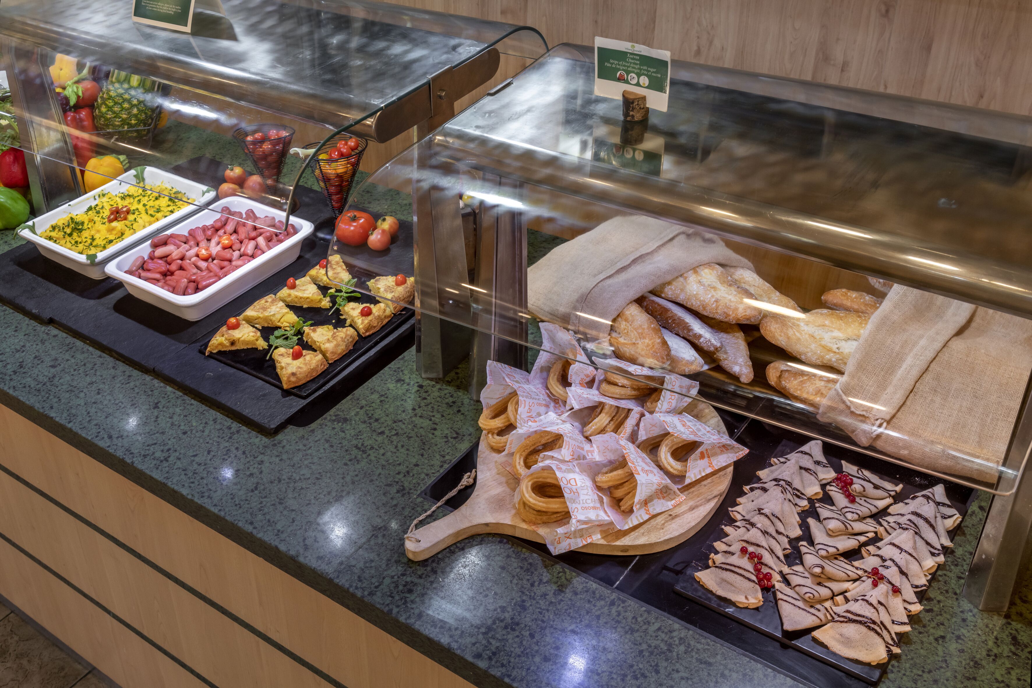 A buffet with various food items including sandwiches, pastries, and a salad.