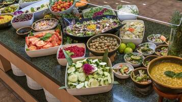 Un bufé con diferentes opciones de comida, como ensaladas, frutas y verduras.