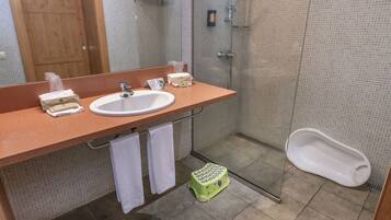Un baño con lavamanos, espejo y ducha.