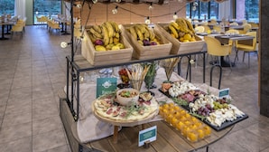 A buffet setup with various fruits, cheeses, and a salad. - Vilar Rural de Sant Hilari by Serhs Hotels (Sant Hilari Sacalm)