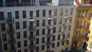 A multi-story building with balconies, a courtyard, and neighboring buildings.