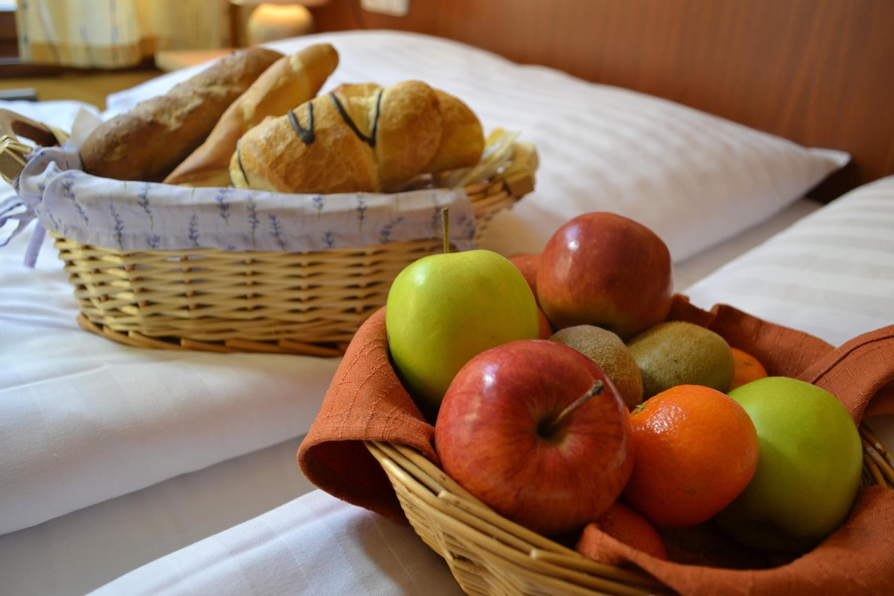 Ein Bett mit einer Obstkorb und einem Brotkorb.