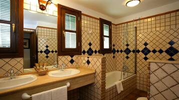 A bathroom with two sinks, a bathtub, and a shower.