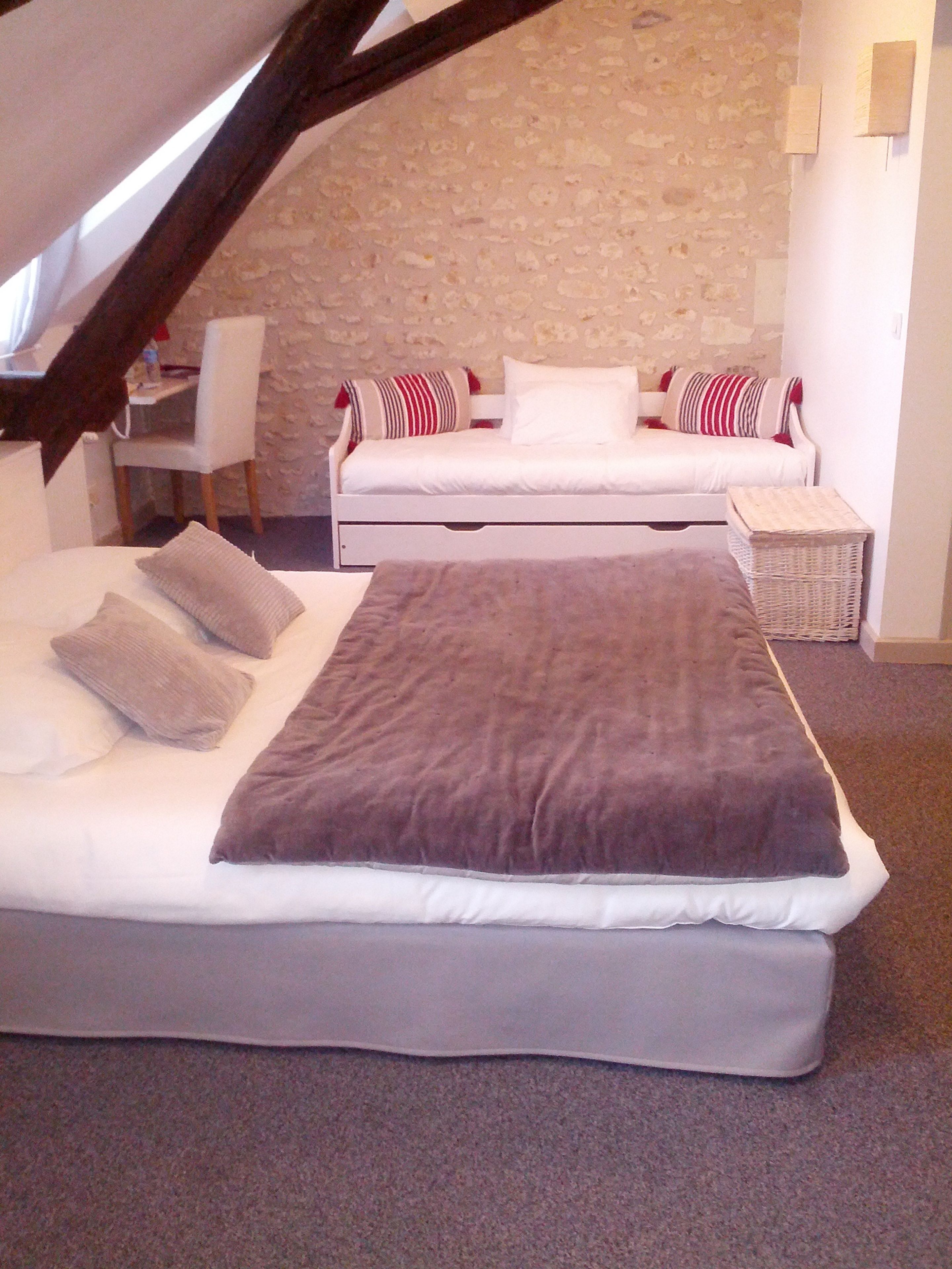 Een slaapkamer met een bed, een bank en een klein tafeltje.
