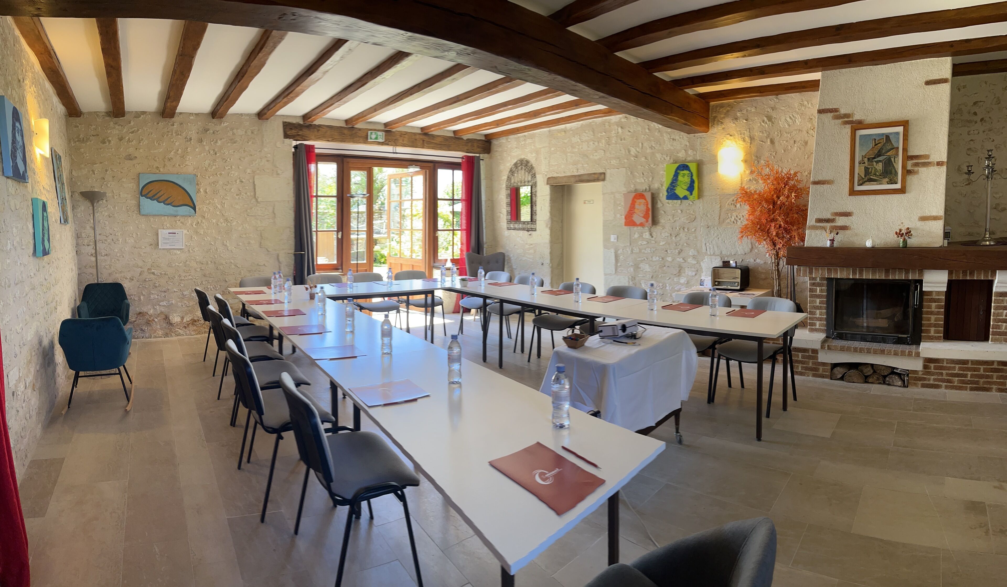 A conference room with long tables, chairs, and a fireplace.