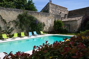 A swimming pool with lounge chairs, surrounded by greenery and stone walls. - Les Jardins de la Livrée (Villeneuve-les-Avignon)