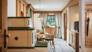 A traditional wooden interior with a dining area, wooden cabinets, and a view through a window.