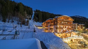 A snow-covered ski resort with a multi-story hotel featuring balconies and a ski lift. - Hotel Chalet del Sogno (Pinzolo)