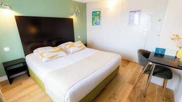 Ein Schlafzimmer mit einem Bett, einem Nachttisch und einem Schreibtisch mit Stuhl.