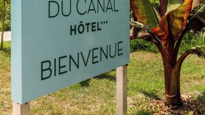 A sign for Les Jardins Du Canal Hotel with a welcome message. - Les Jardins du Canal (Aigues-Mortes)