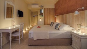 Un dormitorio con cama, mesita de noche, silla y escritorio con otra silla.