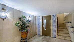 Ein Flur mit Blumentopf, Tür und Treppe.