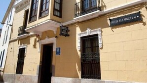 Ein zweistöckiges Gebäude mit einem Schild, auf dem 'HOTEL SAN MIGUEL' steht.