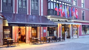 A hotel with outdoor seating and flags. - Gran Hotel Paraiso (Llanes)