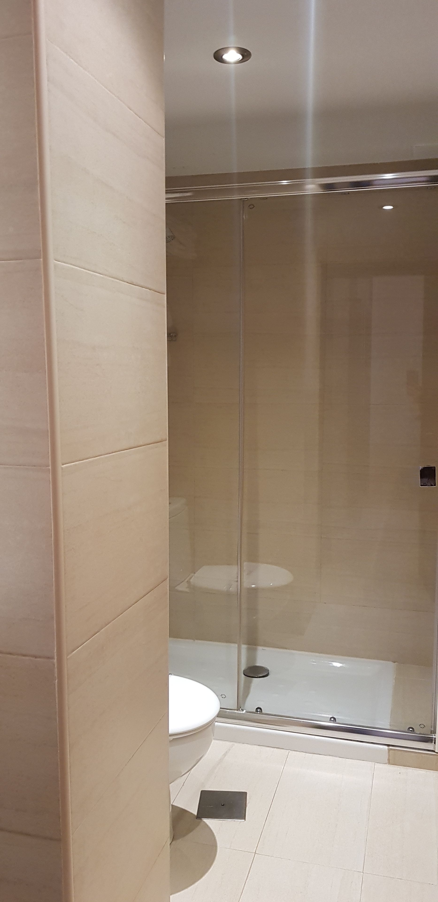 Un bagno moderno con box doccia in vetro, un water e un lavabo.