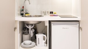 A compact kitchen with a microwave, sink, and refrigerator.