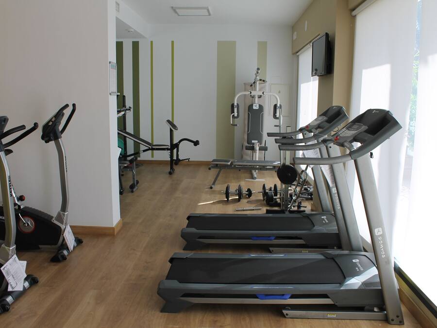 A gym with treadmills, stationary bikes, and weight machines.