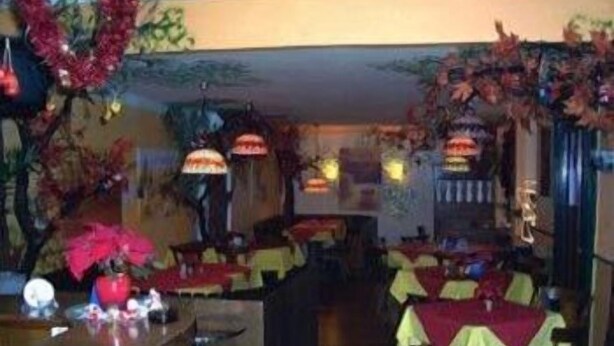 A restaurant interior with multiple tables, chairs, and hanging decorations.