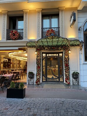 A hotel entrance with a decorated facade, a chandelier, and a dining area visible inside. - Asur Hotel (Istanbul)