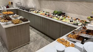 Un bufé con diversos alimentos y una pared de mármol.
