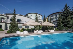 Una piscina al aire libre de temporada, sillones reclinables de piscina