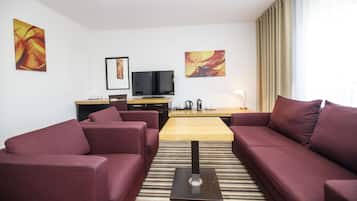 A modern living room with a sofa set, a coffee table, and a flat-screen TV.