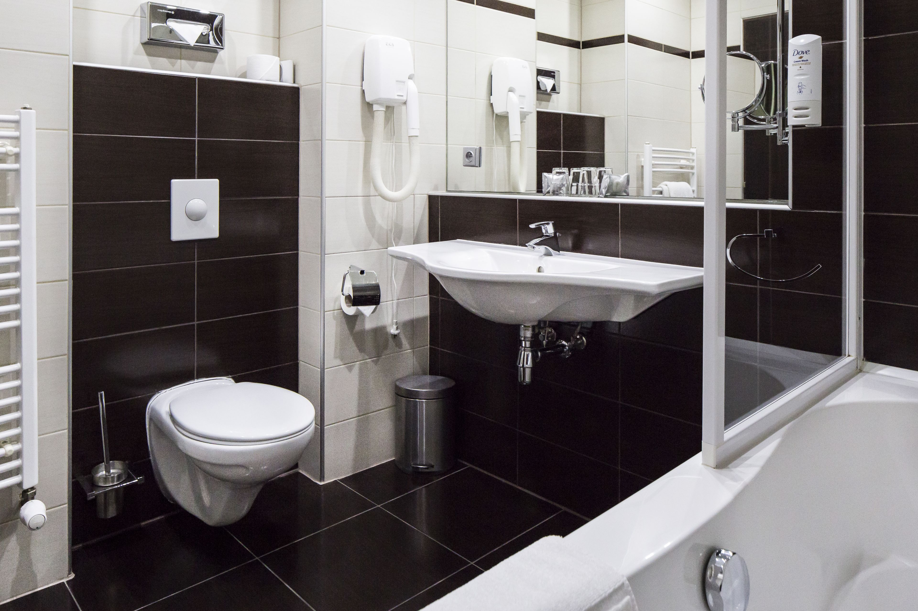 Une salle de bain moderne équipée de toilettes, d’un lavabo et d’une douche.