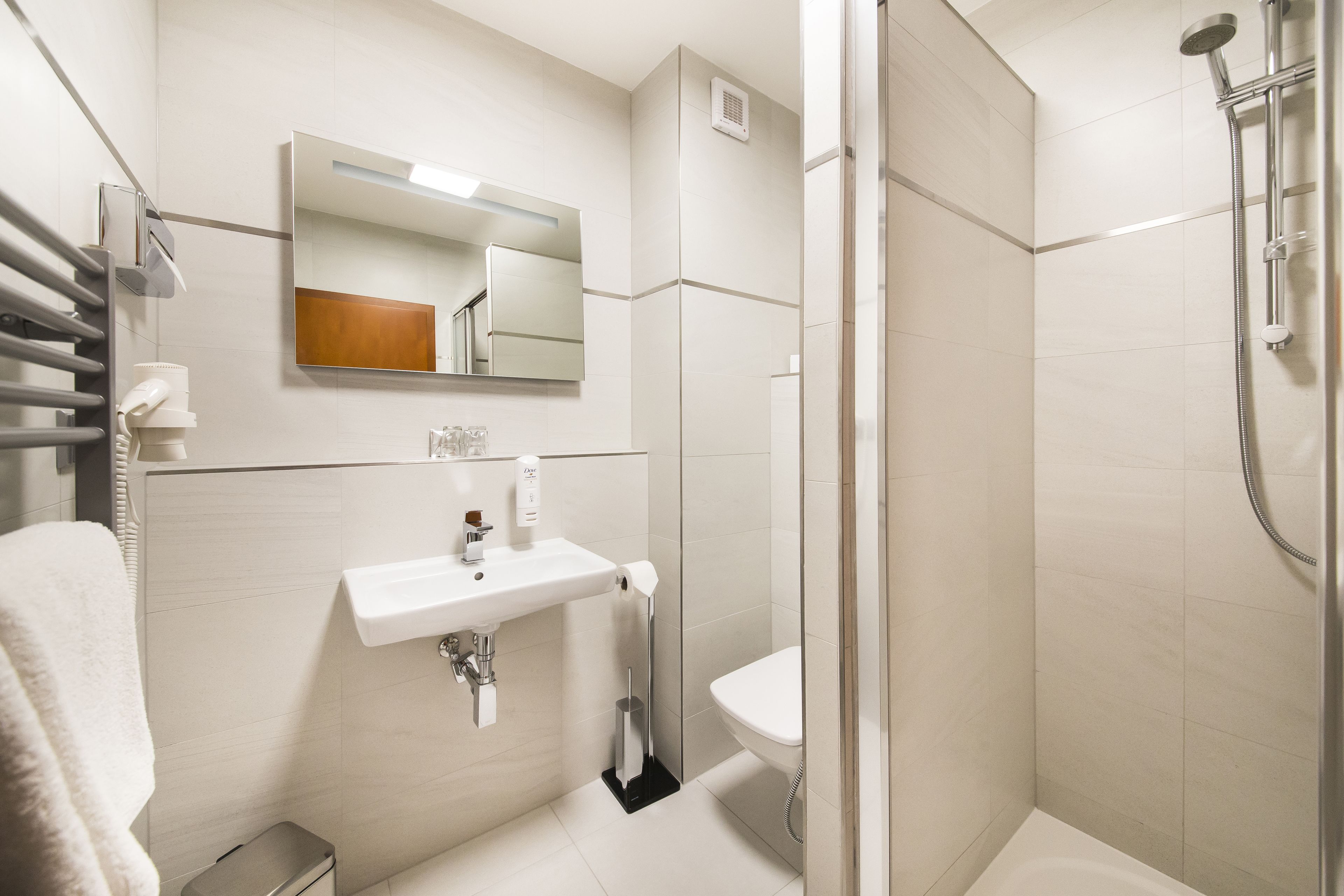 A modern bathroom with a sink, mirror, and shower.