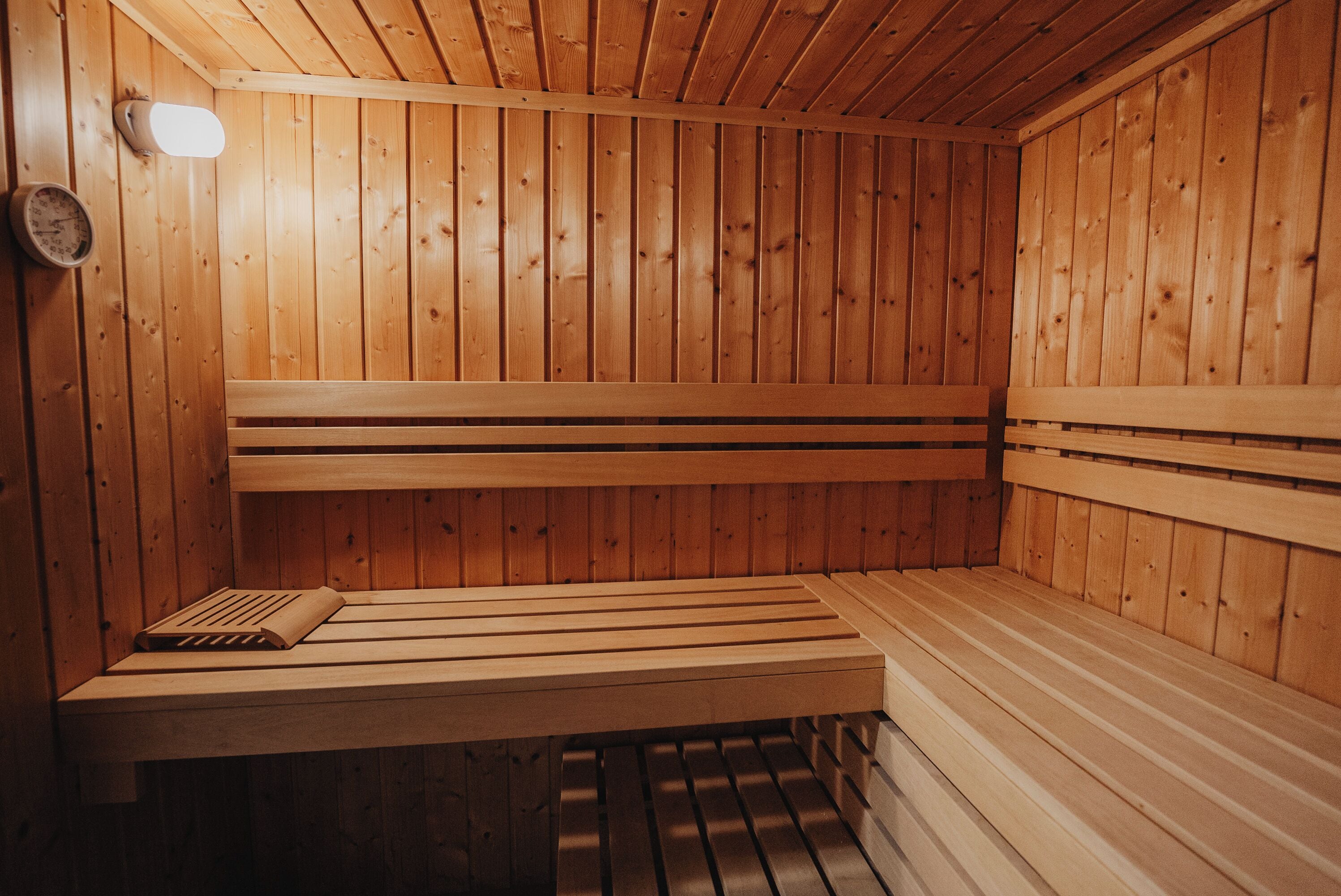 Una sauna de madera con bancos y sistema de ventilación.