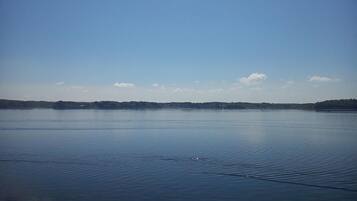 A calm lake with a clear sky and distant land.