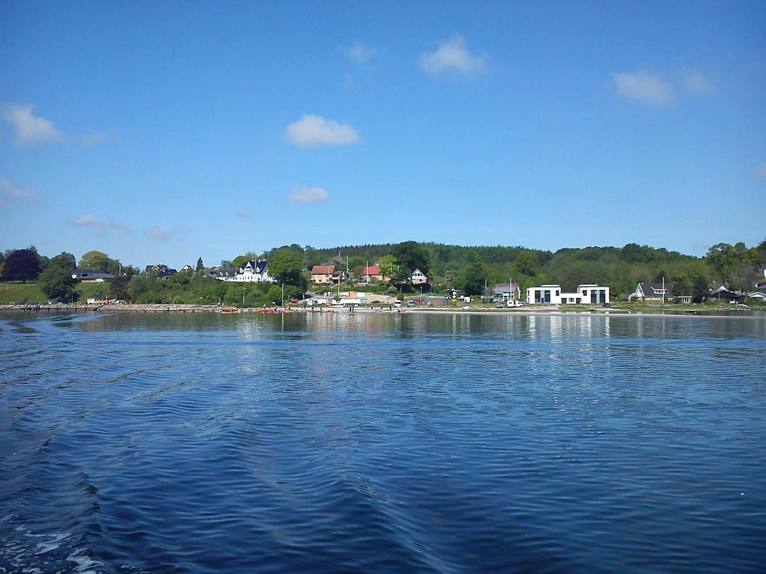 Une vue sur le front de mer, avec des bâtiments, un quai et une eau calme.
