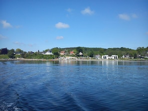 A waterfront view with buildings, a dock, and calm water.