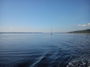 A calm body of water with a sailboat in the distance.