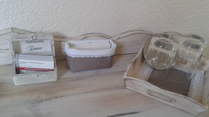 Una mesa de madera con una caja blanca que dice "Apartment & Zimmervermietung" y una caja con lunares y un paño blanco. También hay dos recipientes de vidrio transparentes sobre la mesa.