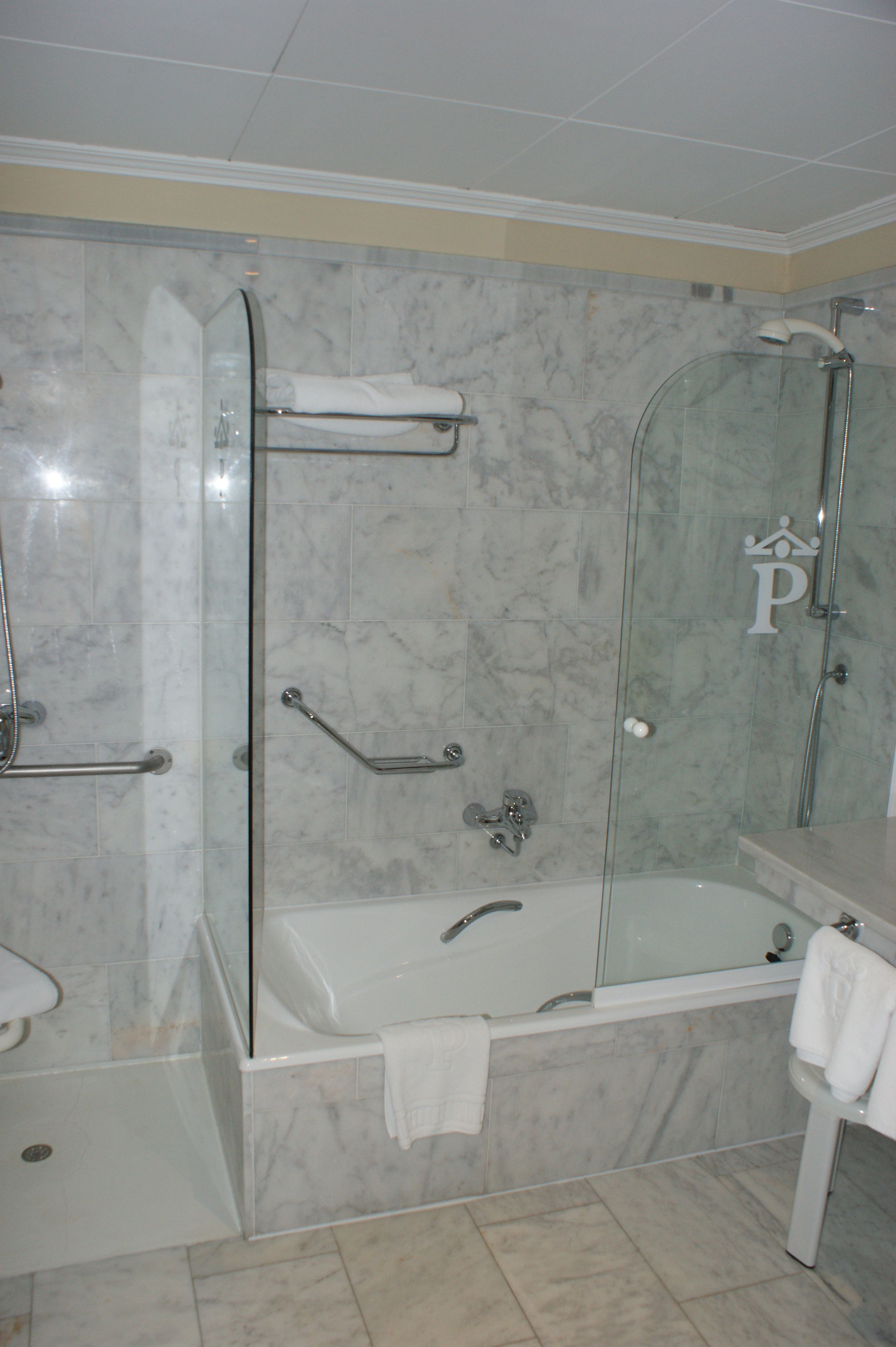 Un baño moderno con ducha envuelta en vidrio, bañera y tocador con espejo.