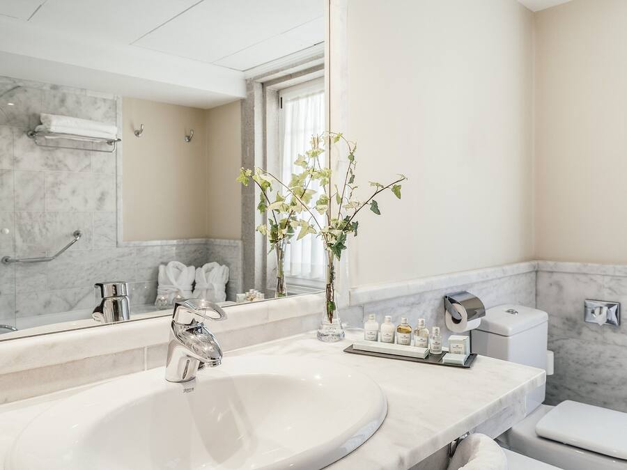 Une salle de bain moderne avec un grand lavabo, un miroir, des toilettes et un espace douche.