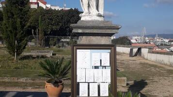 Una estatua de figura clásica sobre un pedestal con una placa de texto.