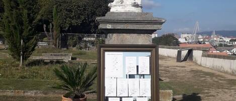 Una estatua de figura clásica sobre un pedestal con una placa de texto.