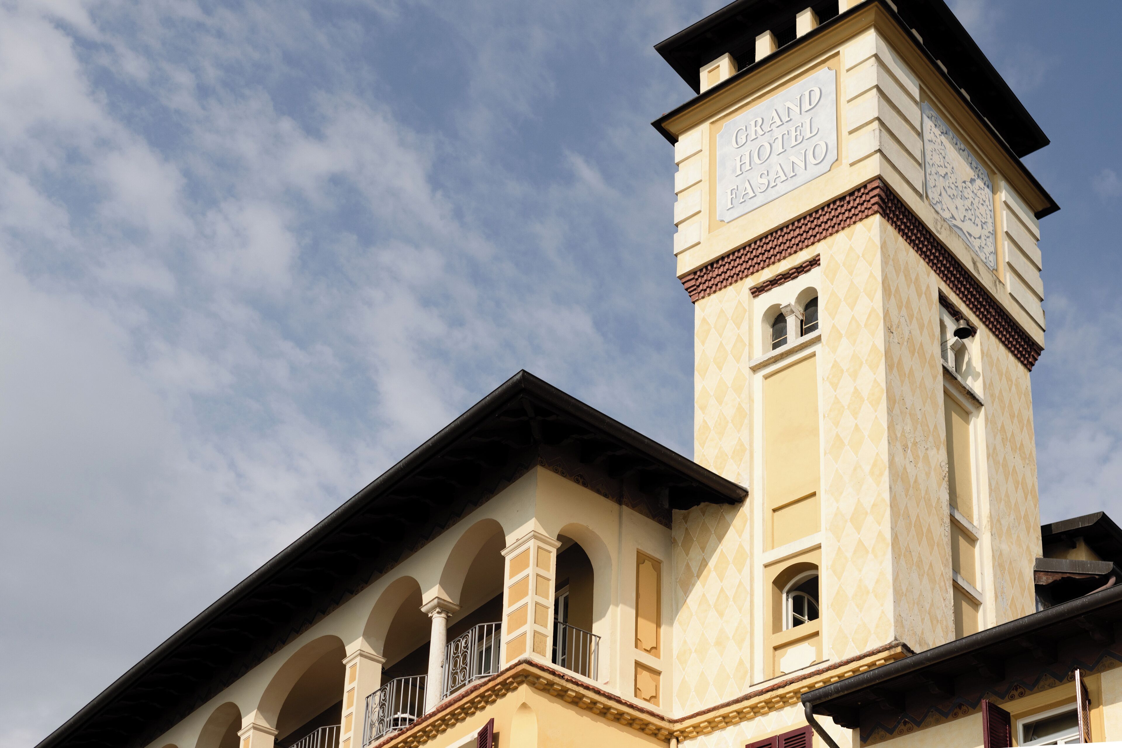 Un hotel con una torre destacada, balcones arqueados y cielo despejado.
