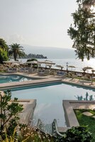 Una piscina techada, una piscina al aire libre, sombrillas