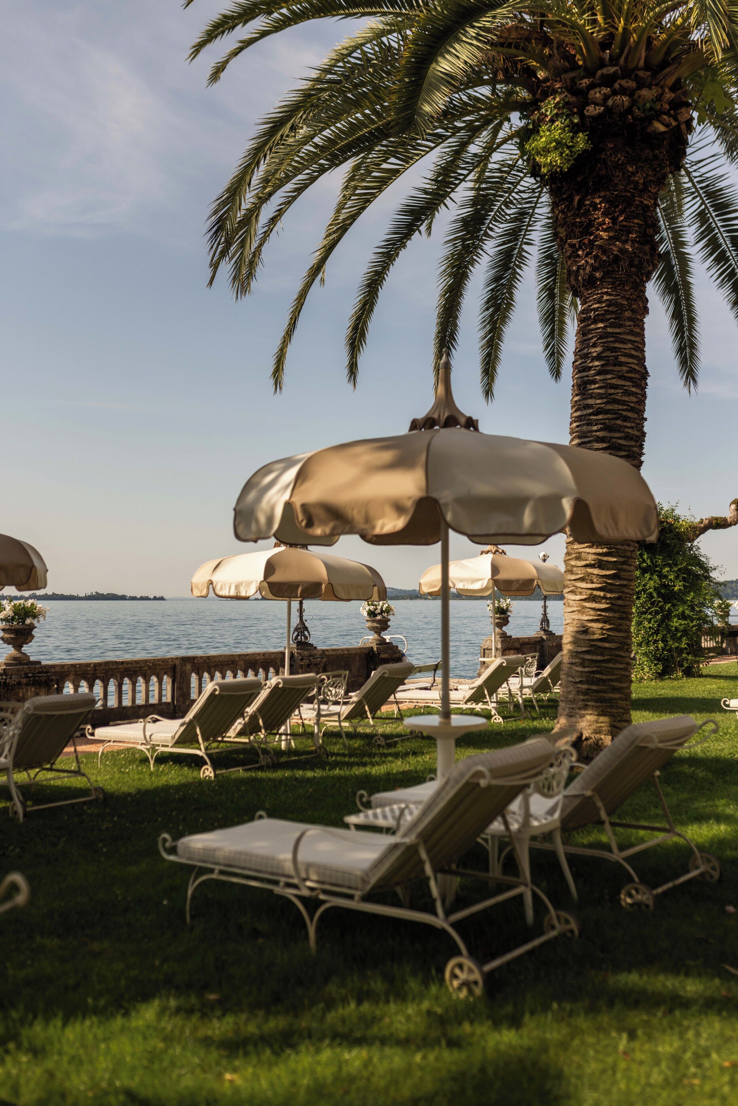 Un área de descanso frente a la playa con sombrillas y sillones.