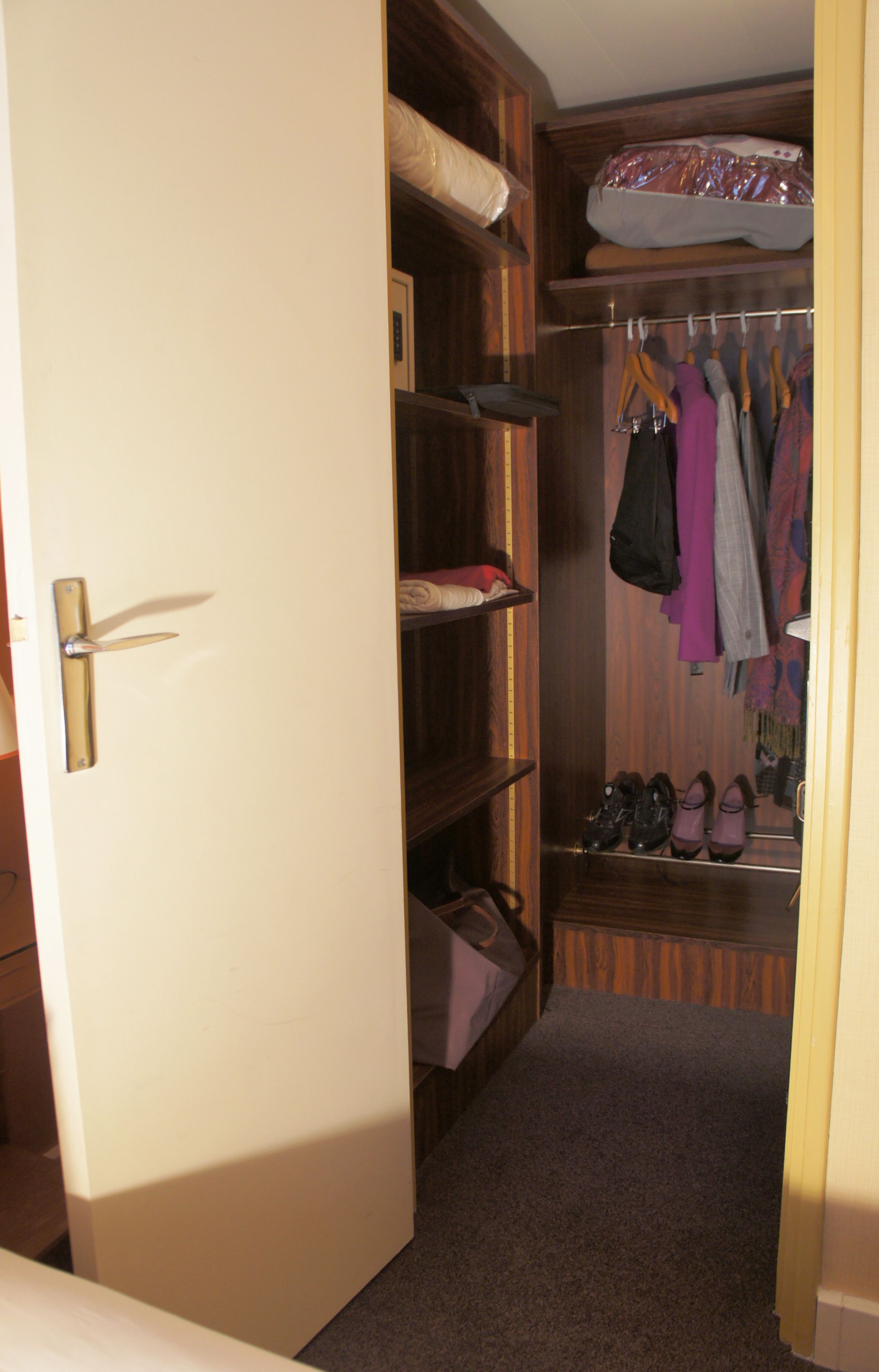 A walk-in closet with shelves, hanging space, and a shoe rack.