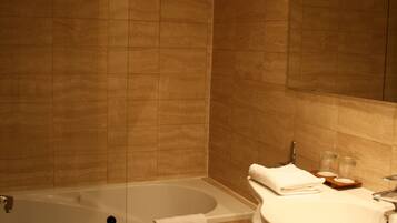 A bathroom with a bathtub, a sink, and a mirror.