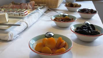 Una mesa de bufé con diversos alimentos y utensilios.