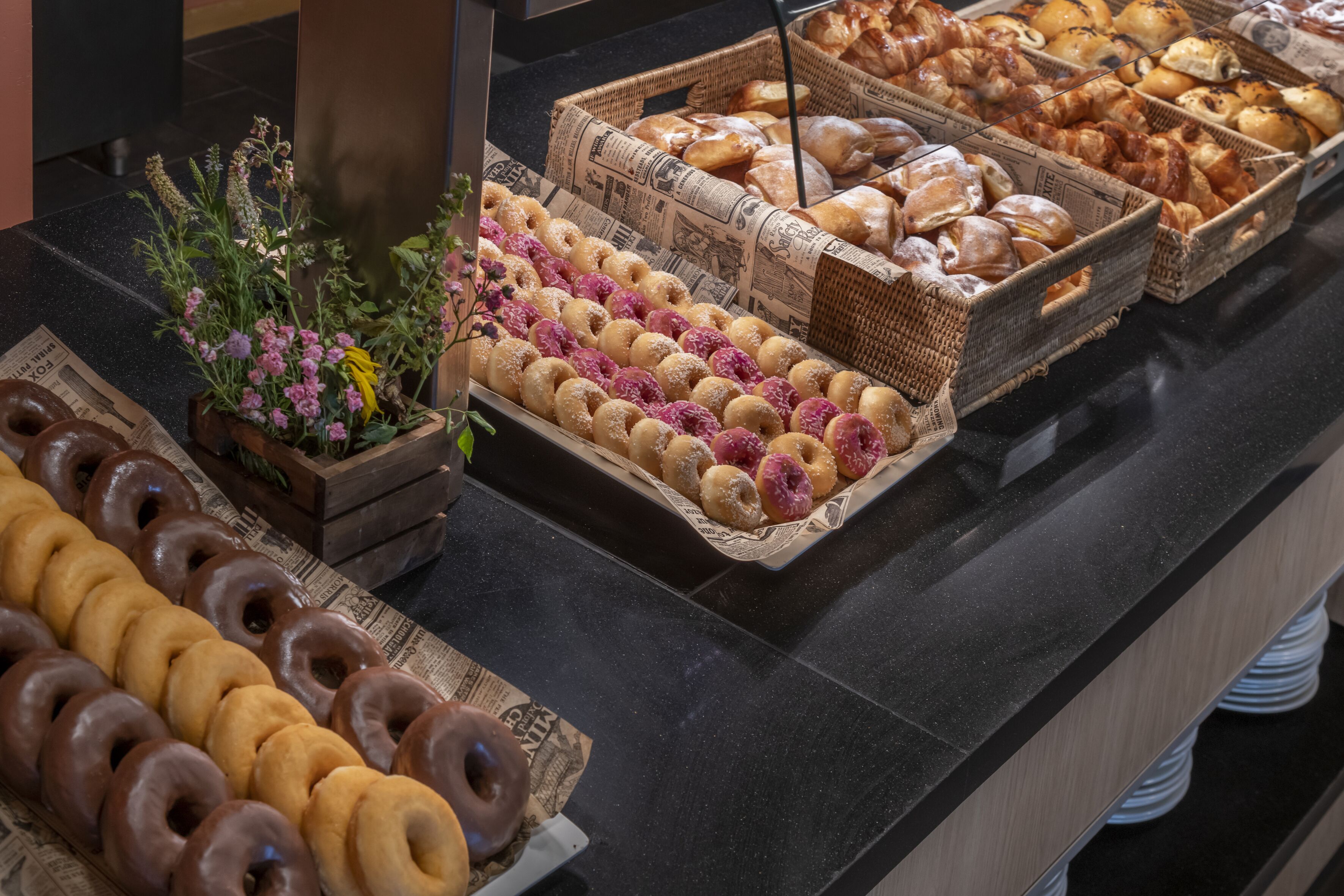 A bakery display with various pastries and donuts.