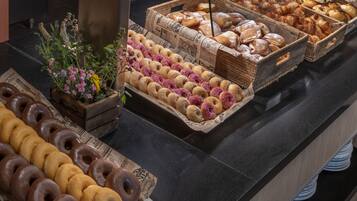 A bakery display with various pastries and donuts.
