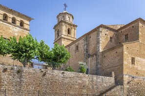 A historic stone building with a bell tower and a staircase leading to a door.